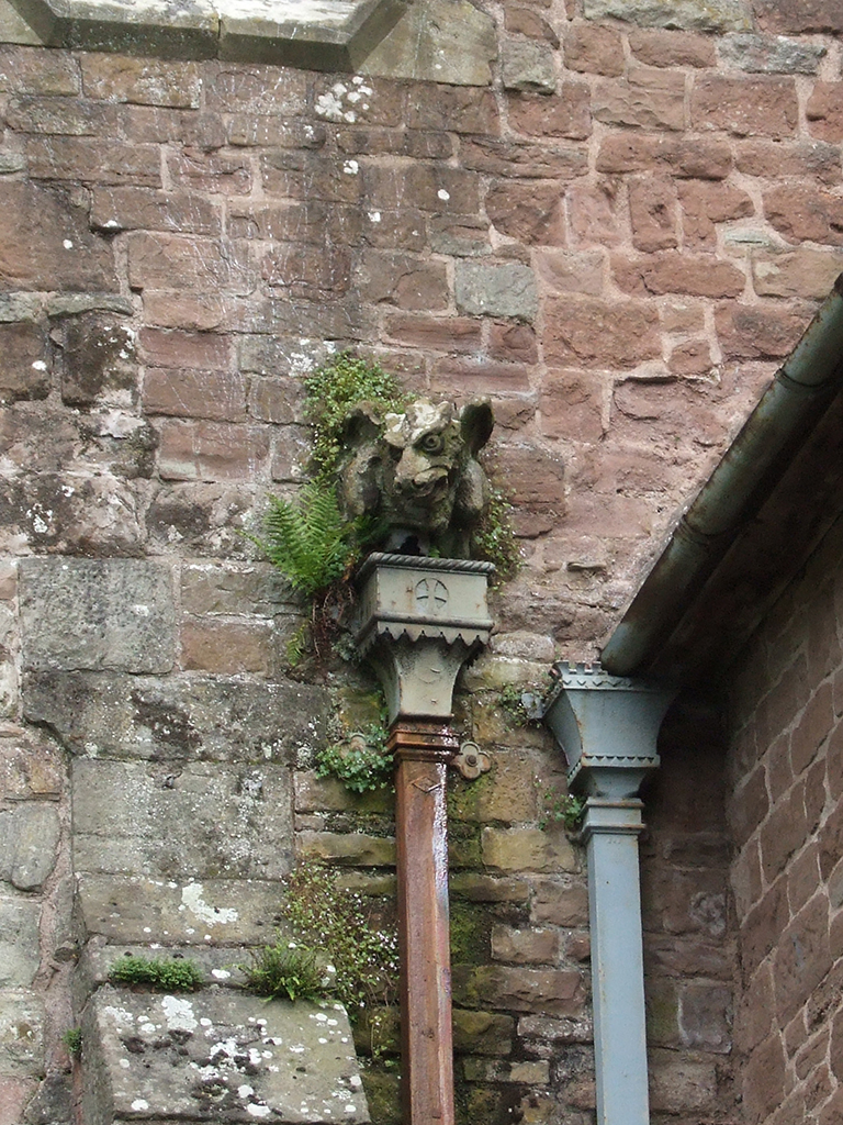 Vegetation growth around hopper head gargoyle